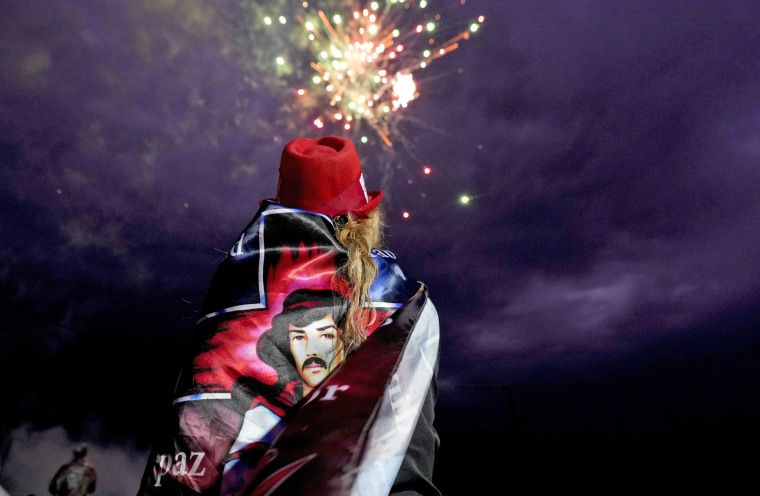 Una mujer observa los fuegos artificiales en el santuario popular de Argentina 