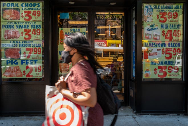 Los precios se publican afuera de una tienda de comestibles en una concurrida calle comercial en el vecindario Flatbush de Brooklyn el 15 de junio de 2022 en Nueva York.