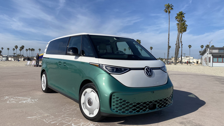 Tres cuartos delanteros disparando un timbre de Volkswagen inactivo en la playa con un color de dos tunas que es verde en la parte inferior y blanca arriba