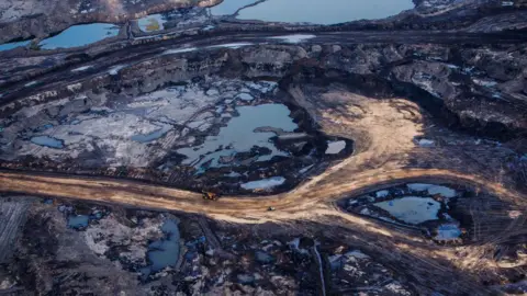 Bloomberg vía Getty Images Una vista aérea de las arenas bituminosas de Athabasca cerca de Fort McMurray, Alberta, que muestra depósitos abiertos de betún de petróleo a lo largo de las vías de servicio minero. 