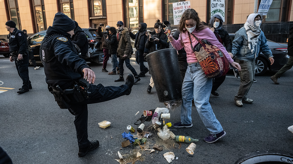 Un oficial de policía de la ciudad de Nueva York arroja basura durante un motín contra ICE en la ciudad de Nueva York el sábado 29 de noviembre de 2025.