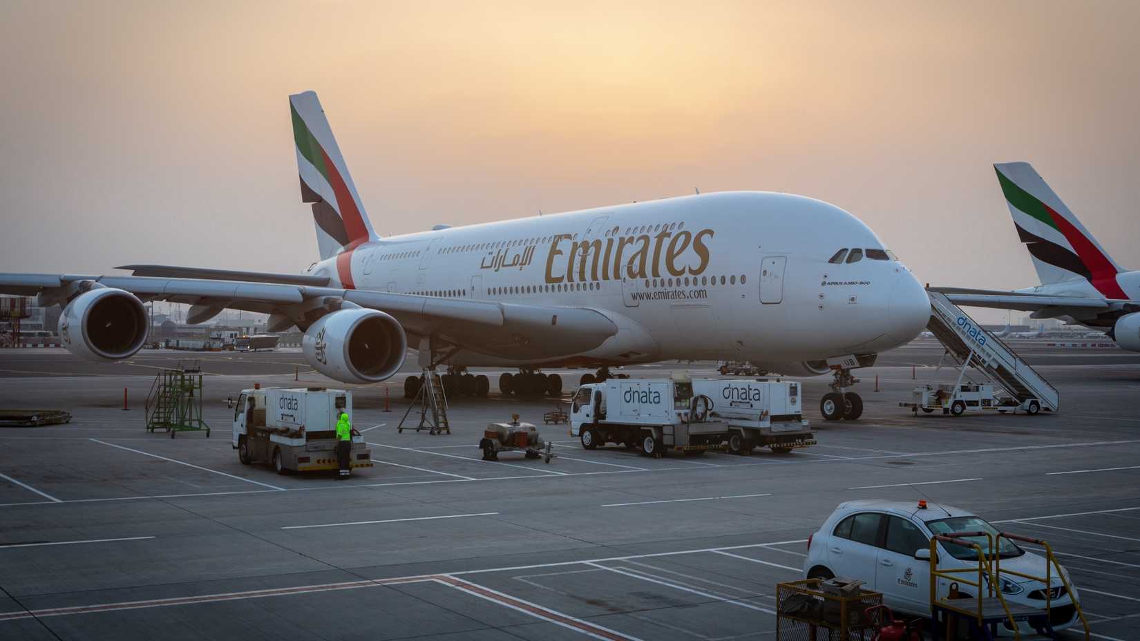 Un A380 de Emirates estacionado en condiciones de poca luz en un stand remoto en Dubai