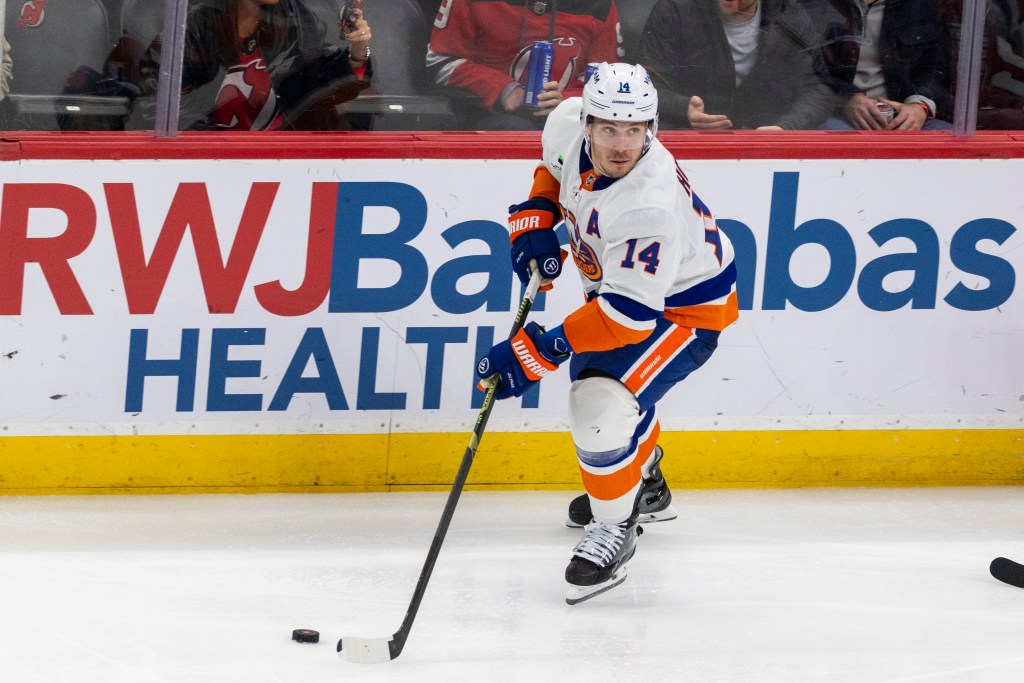 El centro de los New York Islanders, Bo Horvat (14), patina con el disco durante el tercer período contra los New Jersey Devils.