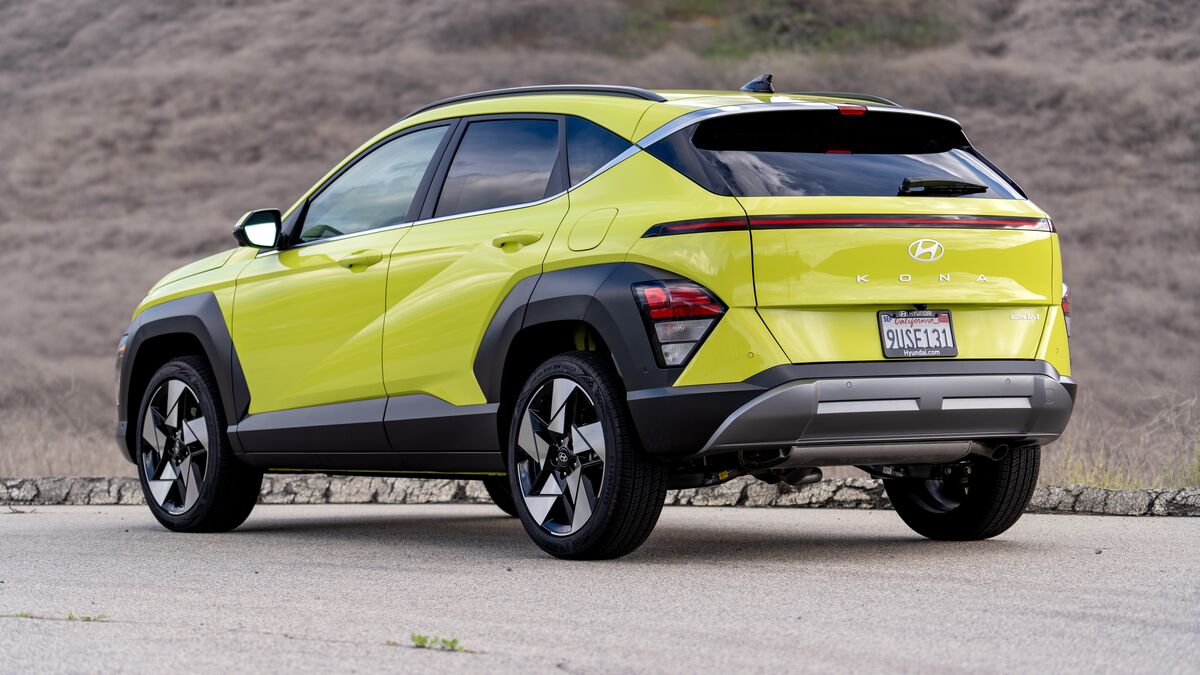 Vista lateral trasera izquierda 3/4 de un Hyundai Kona Hybrid en una ladera cubierta de hierba