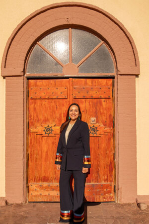 Kristin Serrano (BBA '95, MBA '99) frente a la puerta de la iglesia en Ysleta del Sur Pueblo.